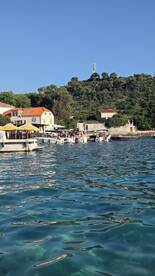 A vibrant harbor scene with multiple boats and people enjoying the sunny day, showcasing the beauty of coastal life.