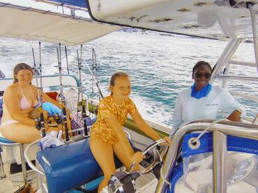 A joyful group enjoys a fishing trip on a boat, with children actively participating and learning the ropes — perfect for family adventures on the water.