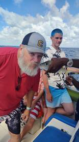 A lively group enjoys a fishing experience on a boat, showcasing their catch and capturing fun moments together — perfect for family outings or group adventures on the water.