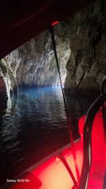 A serene view of a cave with shimmering blue waters, perfect for exploring hidden gems during a boating adventure.