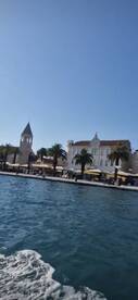 A picturesque view of a coastal town with palm trees and historic architecture, perfect for capturing the essence of a relaxing day on the water.