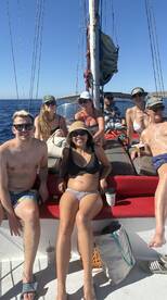 A lively group enjoys a sailing trip, soaking up the sun and celebrating together on the deck. Perfect for friends looking to create unforgettable memories on the water.