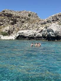 A group of friends enjoys a refreshing swim in crystal-clear waters, celebrating their day out in nature — perfect for summer adventures and memorable experiences.