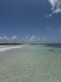 A stunning view of a tranquil beach with crystal-clear waters and a picturesque coastline, perfect for relaxation and exploration.
