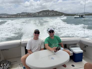 Two friends enjoy a day on the water, capturing the fun of boating with scenic views in the background — perfect for memorable outings and adventures.