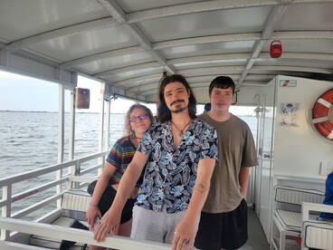 Three friends enjoy their time aboard a boat, showcasing the comfortable interior space perfect for socializing while on the water.