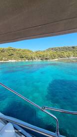 A stunning view of turquoise waters and lush greenery from a boat, showcasing the beauty of the coastline — perfect for nature lovers and boating enthusiasts.