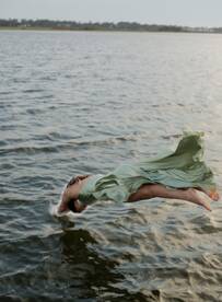 A person leaps gracefully into the water, capturing the thrill of summer fun and adventure on the water.