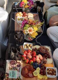 A beautifully arranged charcuterie board featuring fresh fruits, cheeses, and flowers, perfect for enhancing the onboard dining experience.