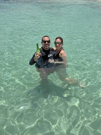 A couple enjoys a refreshing drink while swimming in crystal-clear waters, capturing the essence of a perfect day on the water.