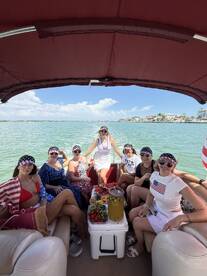 A lively group of friends enjoys a fun day on a pontoon boat, complete with delicious snacks and drinks, perfect for summer celebrations on the water.