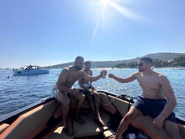 A group of friends enjoys a sunny day on the water, toasting with drinks aboard a boat — a perfect scene for summer celebrations and fun outings.