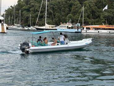A group enjoys a leisurely ride on a small boat, surrounded by a scenic marina filled with other vessels — perfect for exploring coastal waters.