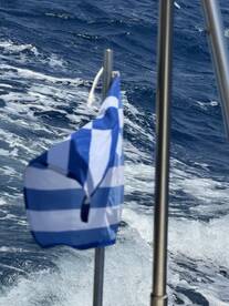 An unclear image featuring a flag against a backdrop of ocean waves, lacking identifiable subjects or context.