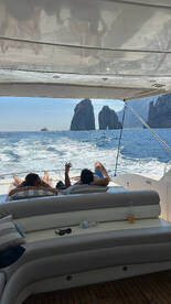 Guests relax on the deck of a yacht while enjoying stunning views of the iconic rock formations in Cabo, creating the perfect backdrop for a memorable day on the water.