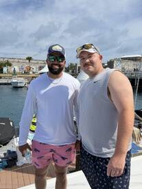 Two friends pose for a photo at the boat dock, ready for a day of adventure on the water. Perfect for capturing memories with friends during a boating trip.