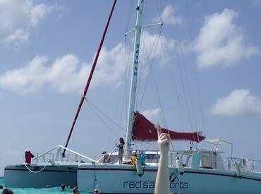 Guests enjoy a lively day in the water around a catamaran, showcasing the fun and excitement of a tropical adventure.