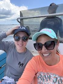 Two friends enjoy a sunny day on the water, capturing a joyful moment aboard their boat. Perfect for showcasing fun boating experiences.