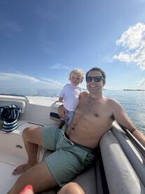 A joyful moment captured of a father and his young child enjoying a sunny day on the boat, perfect for family outings and creating lasting memories on the water.