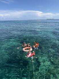 A joyful family enjoys snorkeling in crystal-clear waters, showcasing a perfect day of fun and adventure in the sun.