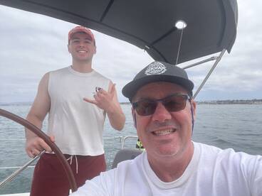 Two friends enjoy a fun moment aboard a boat, capturing a selfie while out on the water — perfect for memorable boating adventures.