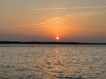 A serene sunset over calm waters, providing a picturesque backdrop for evening boat outings.