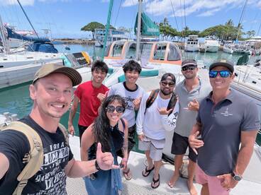 A cheerful group of friends poses for a photo on the deck of a boat, capturing the excitement of their day on the water.