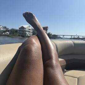 A relaxing moment on a boat with legs stretched out, enjoying the waterfront view — perfect for sunbathing and unwinding on the water.