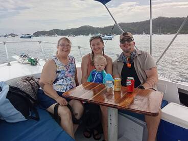 A joyful family enjoys their time aboard a boat, sharing drinks and smiles while surrounded by scenic waters — perfect for family outings and adventures.
