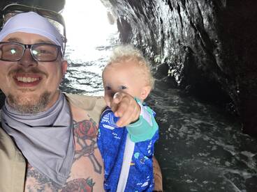 A joyful moment captured inside a cave, showcasing a parent and child exploring the natural beauty of the surroundings — perfect for family adventures on the water.