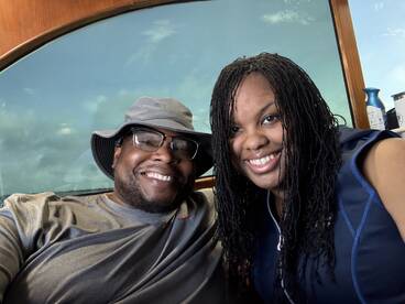 A joyful couple poses for a selfie inside a boat, showcasing their excitement for a memorable day on the water.