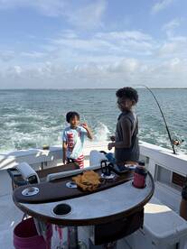 Two children enjoy a fun day of fishing aboard a boat, creating lasting family memories on the open water.