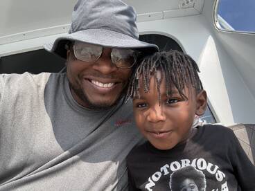 A joyful moment captured between a man and a child aboard a boat, showcasing the fun and bonding experiences that family outings on the water can bring.