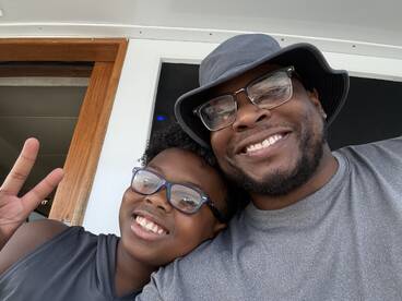 A joyful moment captured between a father and child aboard a boat, showcasing family fun and bonding on the water.