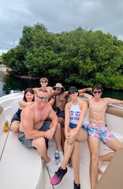 A lively group enjoys a fun day on the boat, surrounded by lush greenery — perfect for memorable outings and celebrations on the water.