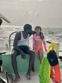 A joyful moment captured on a boat, featuring a smiling child and an adult enjoying their time together on the ocean — perfect for family adventures.