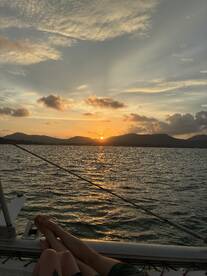 A couple enjoys a romantic sunset view from the deck of a yacht, creating a perfect backdrop for memorable moments on the water.
