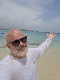 A man enjoys a sunny day at the beach, showcasing the beautiful ocean scenery — perfect for beach lovers and adventure seekers.