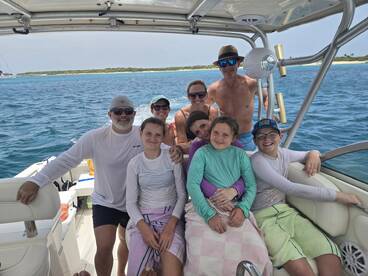 A joyful family poses together on a boat, enjoying their time on the water — perfect for creating lasting memories during summer adventures.