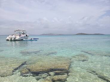 A motorboat is anchored in crystal-clear waters, showcasing a serene marine environment perfect for exploration and relaxation.