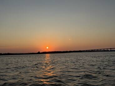 A serene sunset over the water, capturing the tranquil beauty of the evening sky — perfect for romantic boat rides or peaceful reflections.