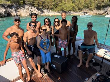 A joyful family poses together on a boat, enjoying a sunny day on the water — perfect for creating lasting memories during summer adventures.