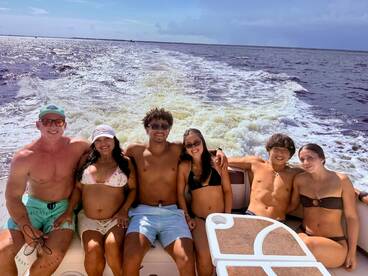 A lively group enjoys a sunny day on the boat, capturing the essence of summer fun and camaraderie on the water.