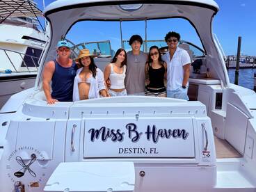 A cheerful group of friends poses aboard the 'Miss B Haven' yacht in Destin, FL, capturing the essence of fun and celebration on the water.