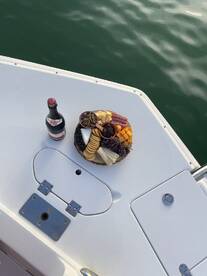 A beautifully arranged charcuterie board featuring cheeses, meats, and fruits, perfect for enjoying on a boat. Ideal for a relaxing day on the water.