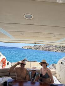 A joyful family enjoys their time on a boat, capturing a memorable moment with stunning ocean views in the background — perfect for family outings and celebrations.
