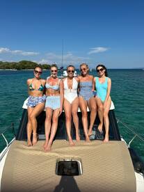 A group of friends enjoys a sunny day on a boat, showcasing the perfect setting for a fun day out on the water.