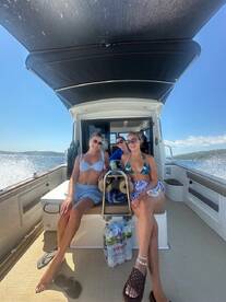Three friends enjoy a sunny day on a boat, capturing the essence of summer fun and friendship on the water.