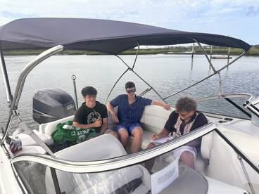 A group of friends enjoys a relaxing moment on a boat, surrounded by calm waters — perfect for a day of fun and camaraderie on the water.