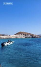A speedboat navigates the crystal-clear waters near Antiparos, showcasing the stunning coastal scenery and inviting adventure on the open sea.